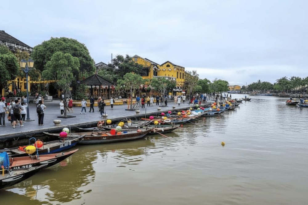 A lively scene along the Hoai River in Hoi An, Vietnam, with colorful lantern-adorned boats and bustling streets